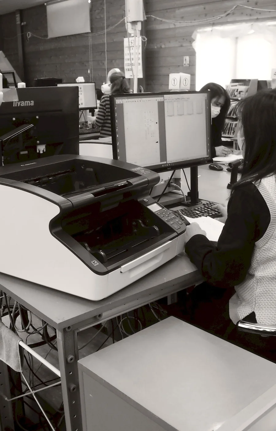 スキャナーで書類を電子化する作業員